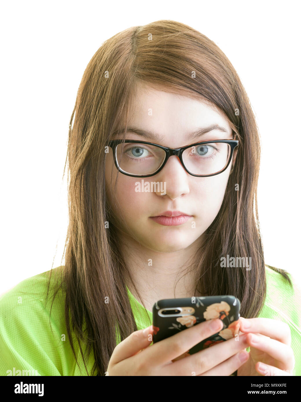 Close up ritratto di una bruna giovani caucasici ragazza adolescente utilizza lo smartphone isolato su uno sfondo bianco modello di rilascio: Sì. Proprietà di rilascio: No. Foto Stock
