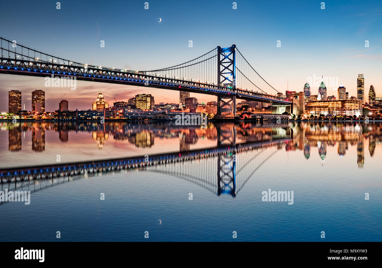 Philadelphia skyline di notte e Ben Franklin Bridge da riflessione attraverso il Fiume Delaware Foto Stock