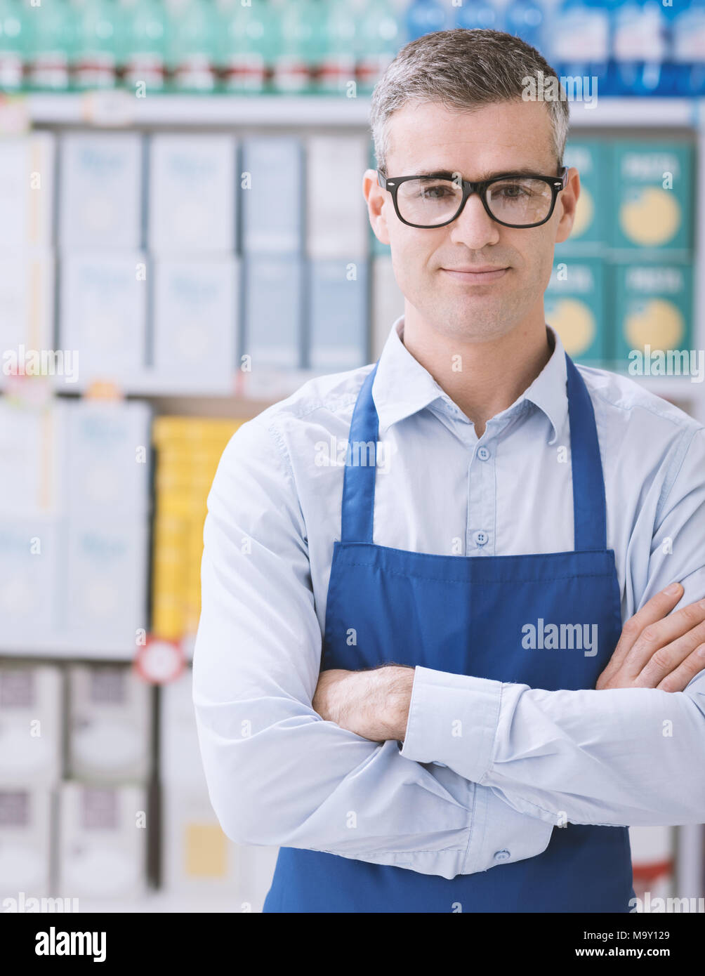 Fiducioso sorridente addetto supermercato che pongono al centro commerciale al dettaglio il concetto di lavoro Foto Stock