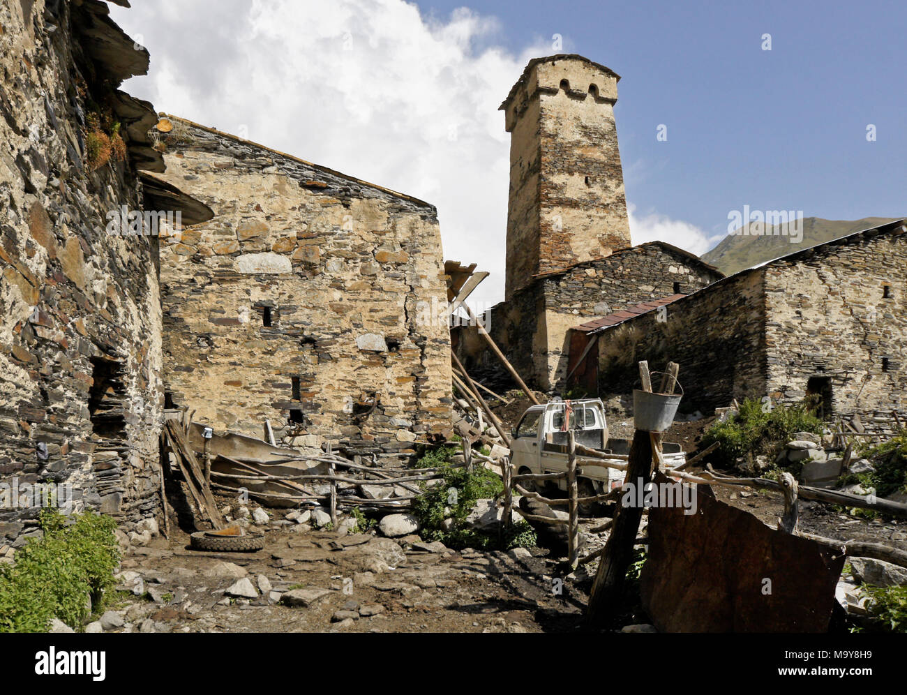 Un medievale torre difensiva si innalza al di sopra del più recente case di pietra del villaggio Ushguli, Svaneti superiore, Georgia Foto Stock