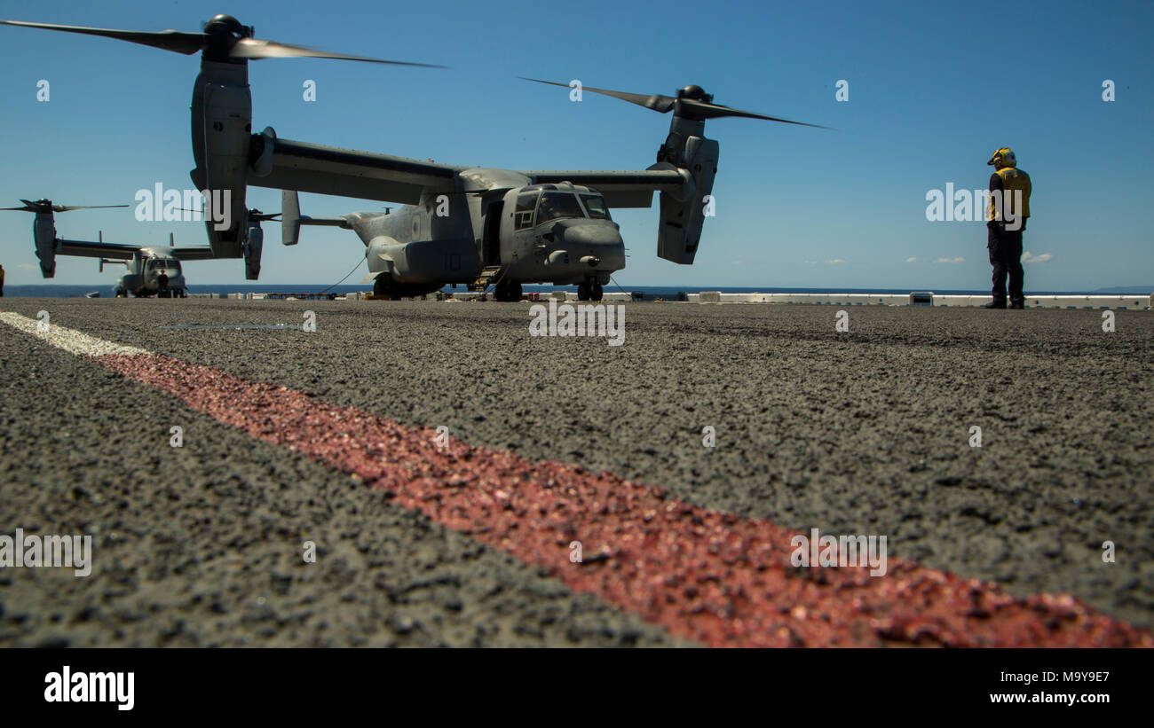 Petty Officer di terza classe Hao Vu, ponte di volo direttore a bordo del Wasp-classe nave anfibio USS Essex (LHD 2), fornisce la direzione per la MV-22 Osprey in attesa di decollo, Marzo 26, 2018. La Osprey è stata assegnata per il trasporto dei marines per un esercizio come parte del XIII Marine Expeditionary Unit del primo in mare periodo. L'Essex anfibio gruppo pronto e il XIII MEU completamente integrate per la prima volta prima della loro implementazione in estate. Squadrone anfibio, MEU integrazione la formazione è un elemento cruciale di pre-distribuzione esercizio che consente al corpo di Navy-Marine team rapidamente a pianificare ed eseguire operazioni complesse fr Foto Stock