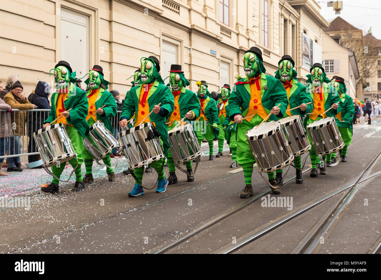 Il Carnevale di Basilea. Steinenberg, Basilea, Svizzera - Febbraio 21st, 2018. Il gruppo Carnival in Cavalletta verde costumi giocando rullante Foto Stock