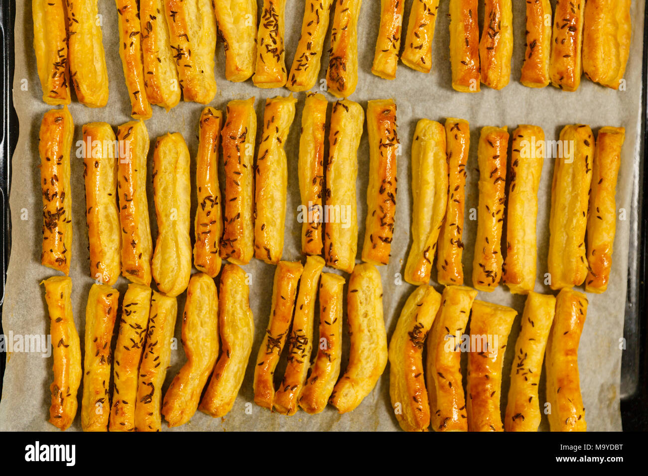 Primo piano di un vassoio con pane appena sfornato, formaggi crackers con semi di cumino Foto Stock