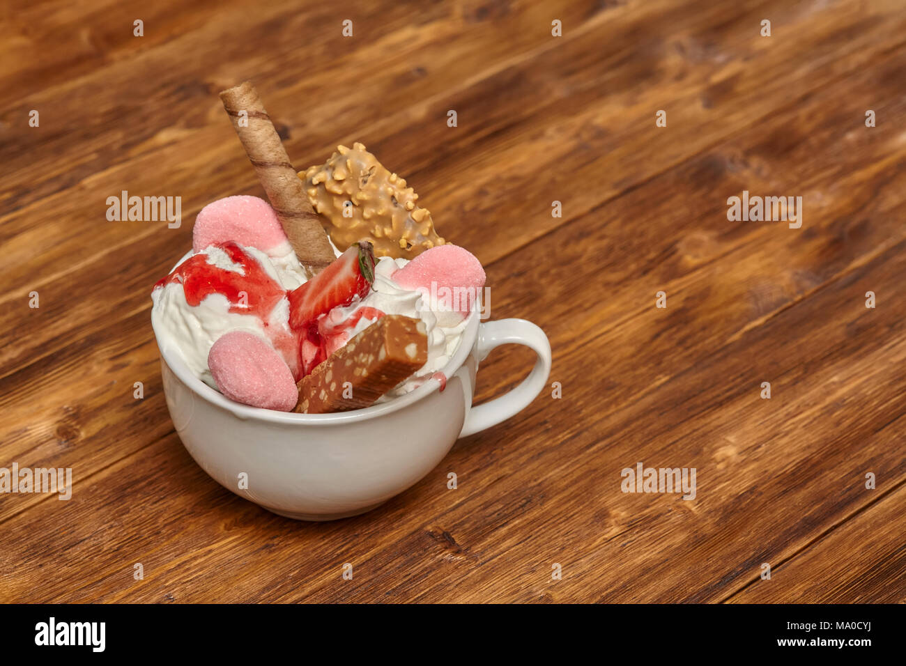 Gelato gelato cocktail nella ciotola con il wafer e candy su sfondo di legno Foto Stock