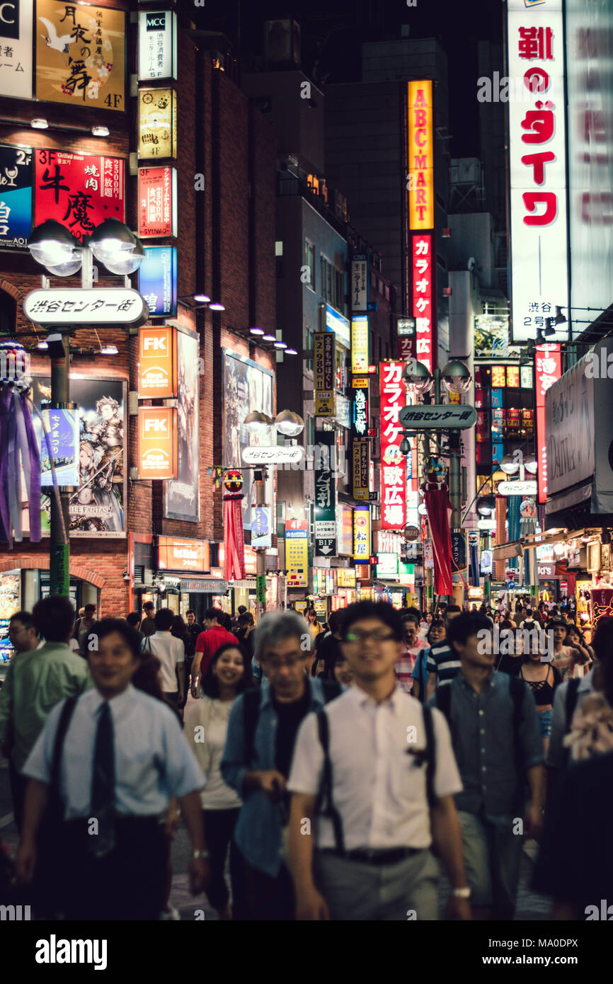 Shibuya (Tokyo, Giappone) - La strada affollata in Shibuya di notte con folla indistinta e insegne luminose. Foto Stock