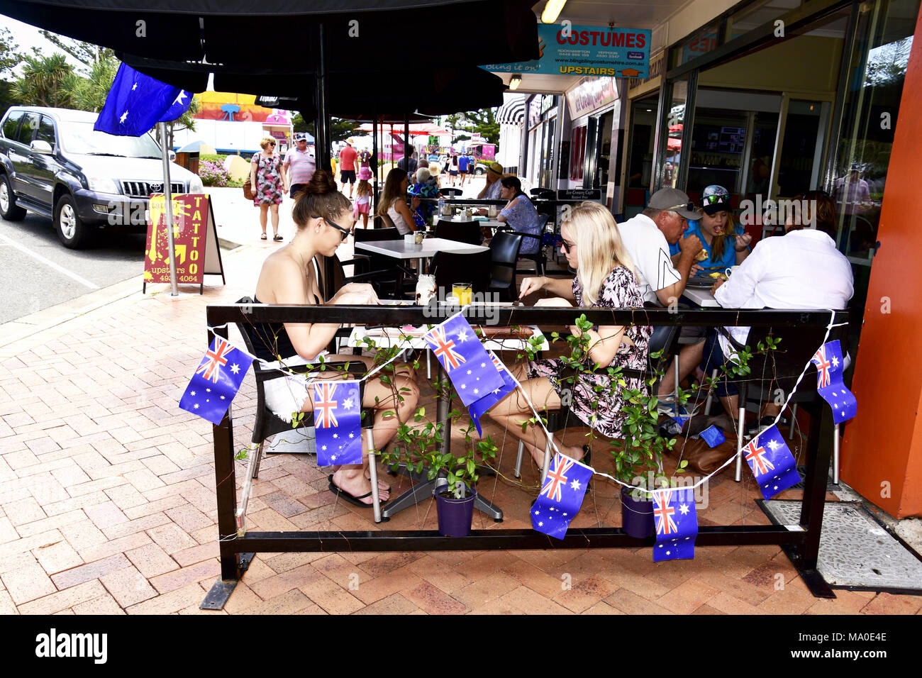 Giovani donne godendo di un AUSTRALIA GIORNO COLAZIONE IN UN LATO A PIEDI CAFE Foto Stock