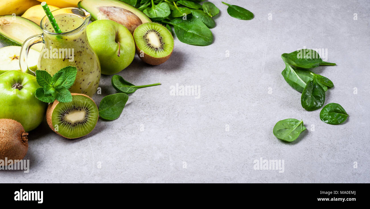 Un sano frullato verde e gli ingredienti su sfondo grigio. Frullato di kiwi con frutti. Superfoods, dieta disintossicante, salute cibo vegetariano concetto. Lunga w Foto Stock