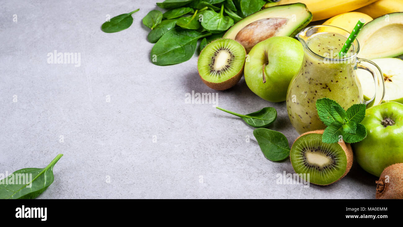 Un sano frullato verde e gli ingredienti su sfondo grigio. Frullato di kiwi con la frutta e la verdura. Superfoods, dieta disintossicante, salute cibo vegetariano Foto Stock