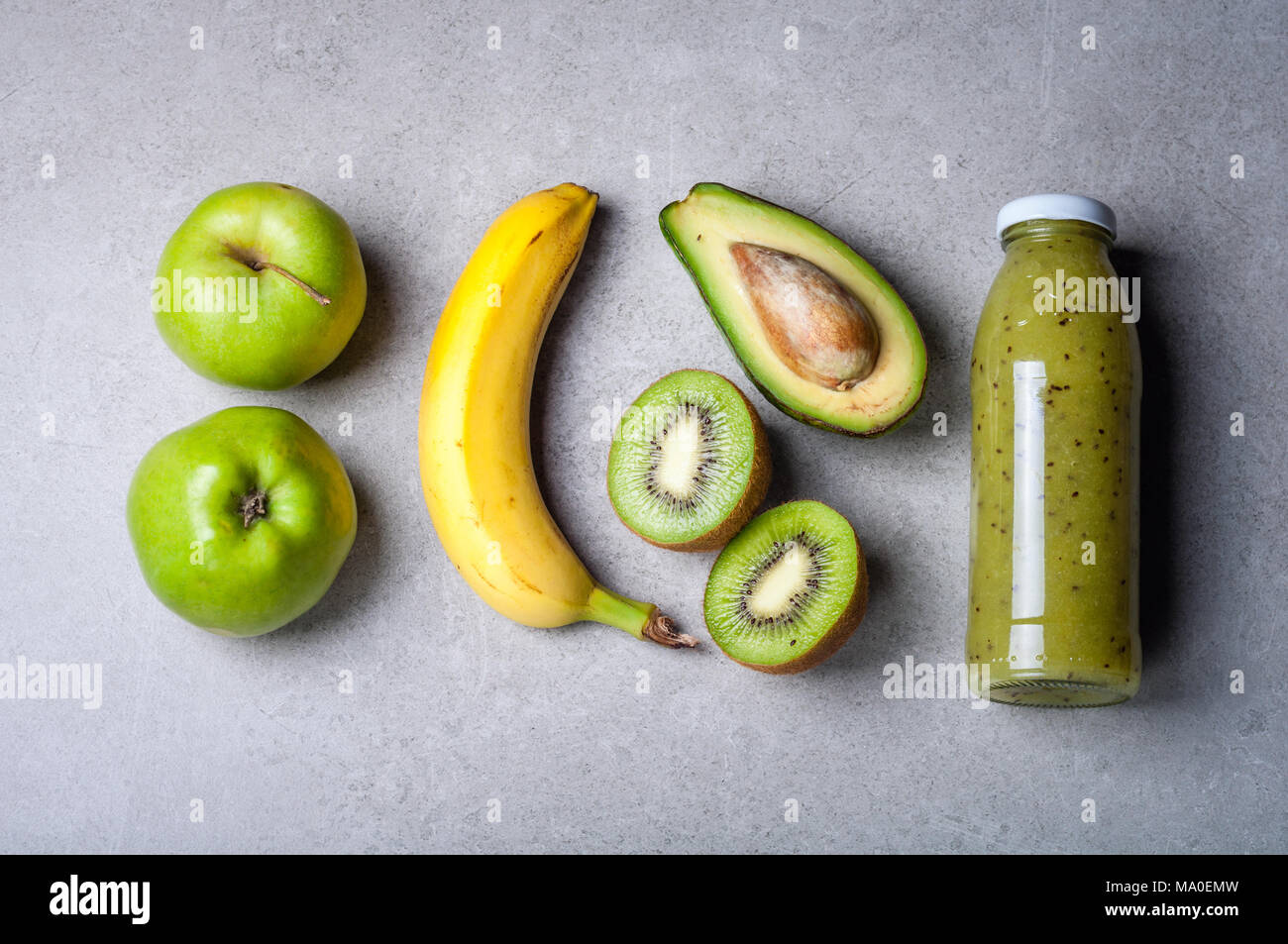 Un sano frullato verde e gli ingredienti su sfondo grigio. Frullato di kiwi con frutti. Superfoods, dieta disintossicante, salute cibo vegetariano concept Foto Stock