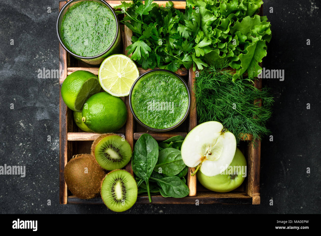 Frullato di verde con ingredienti sul calcestruzzo scuro tavolo. Frullato sano cocktail con frutta e verdura e hebs. Cibo sano e concetto di dieta. A Foto Stock