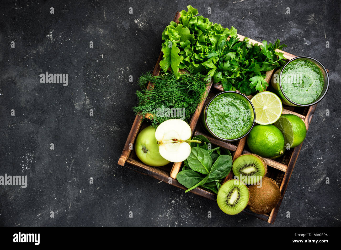 Frullato di verde con ingredienti sul calcestruzzo scuro tavolo. Frullato sano cocktail con frutta e verdura e hebs. Cibo sano e concetto di dieta. A Foto Stock