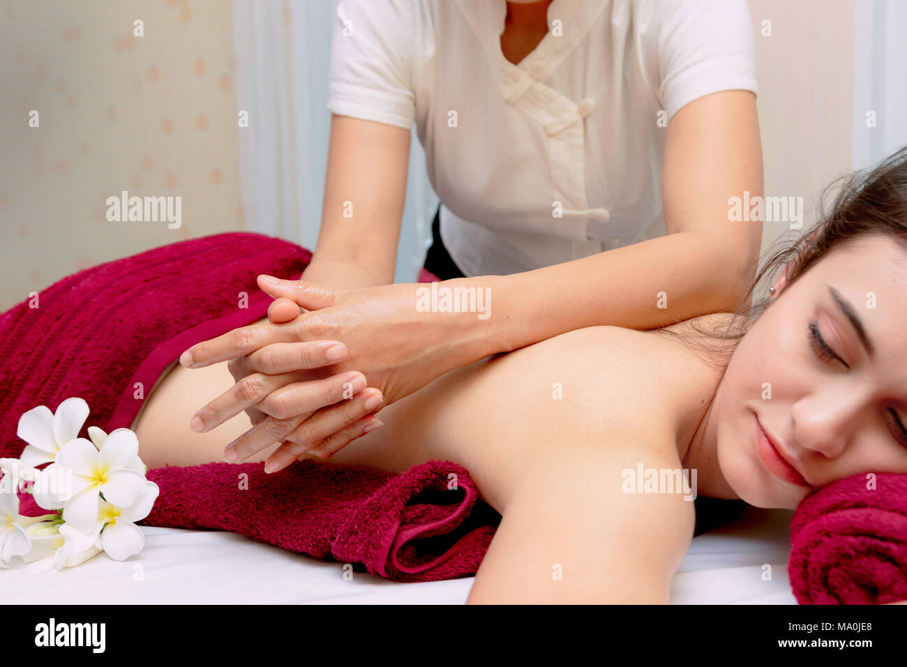 Bella donna rilassata ricevere massaggio alla schiena con olio aromatico Foto Stock
