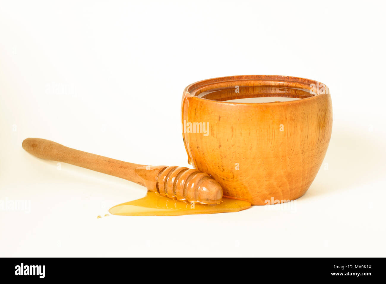 Il miele in una ciotola di legno con un miele speciale bilanciere. Foto Stock