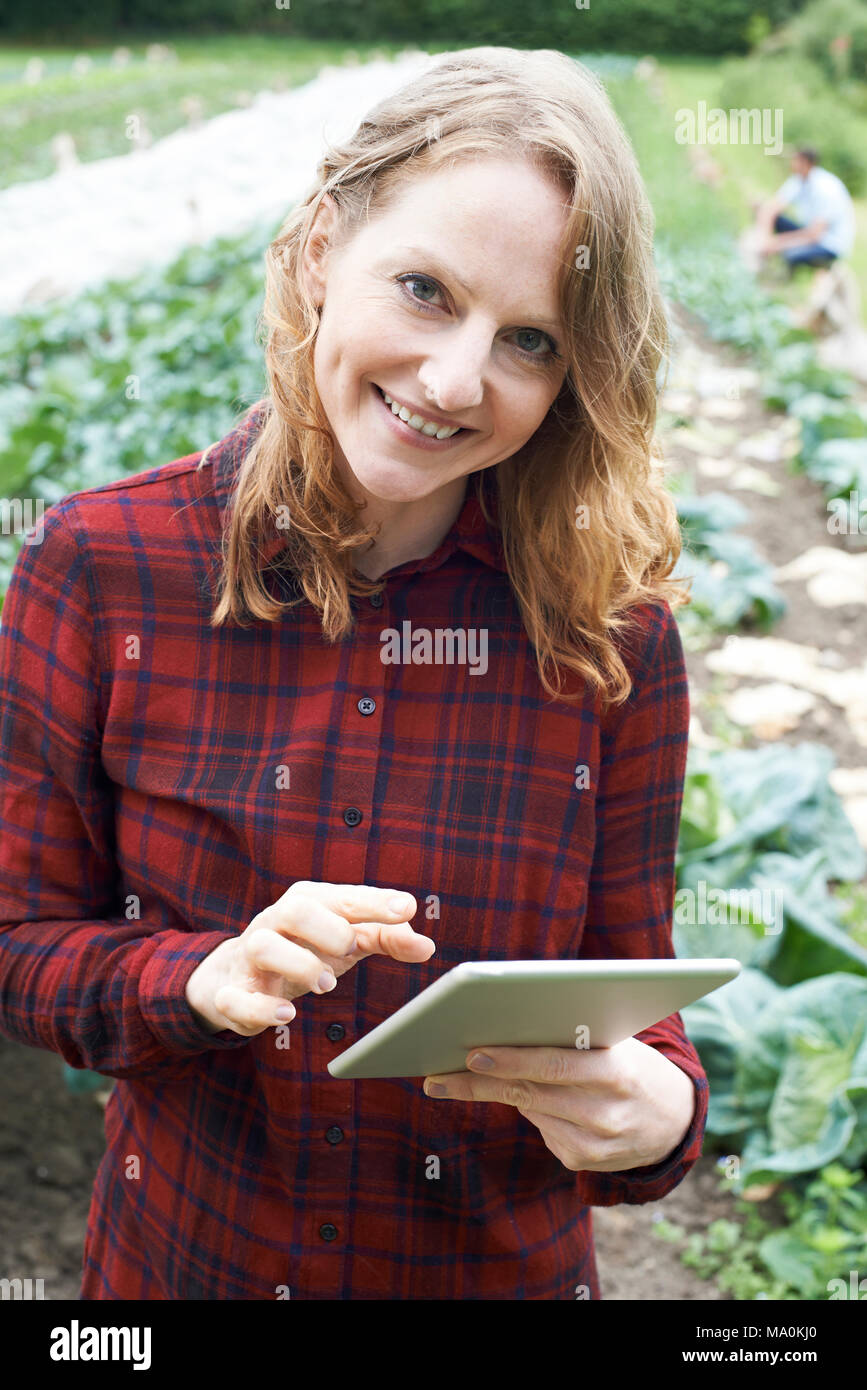 Ritratto di donna lavoratrice agricola con tavoletta digitale nel campo Foto Stock
