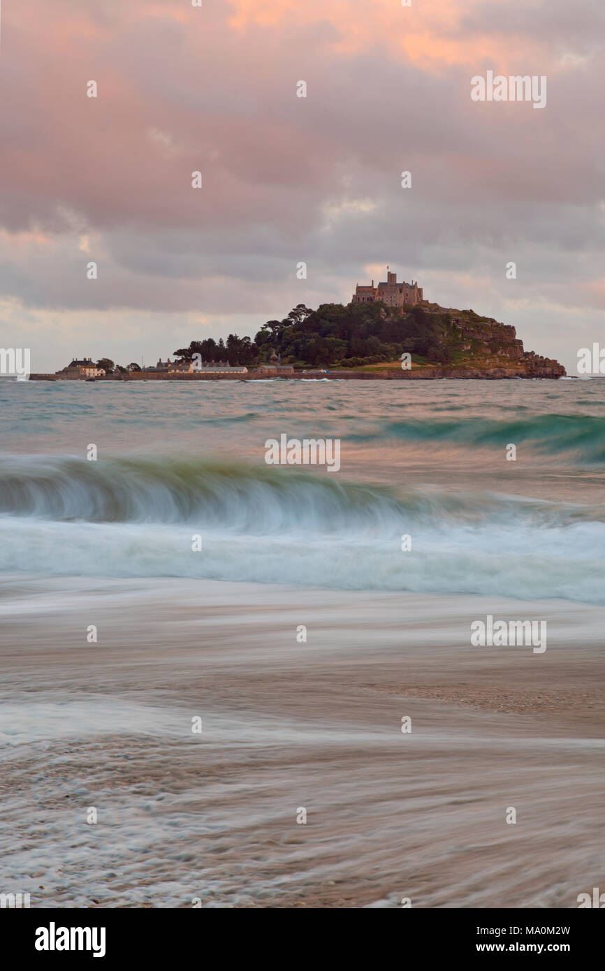 Serata estiva con delicate tonalità pastello del tramonto tra le nuvole su St Michael's Mount in Cornovaglia, i patterns sono formate come shingle sulla spiaggia è il dott. Foto Stock