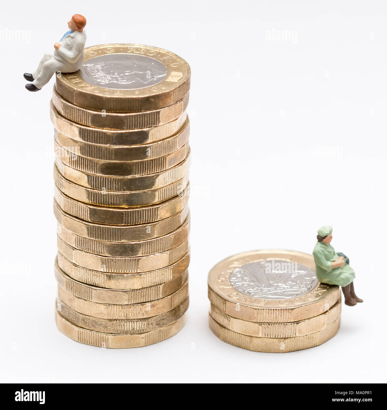 Sesso pagare la parità Concetto di immagine di un uomo e di una donna su una pila di libbra di monete Foto Stock