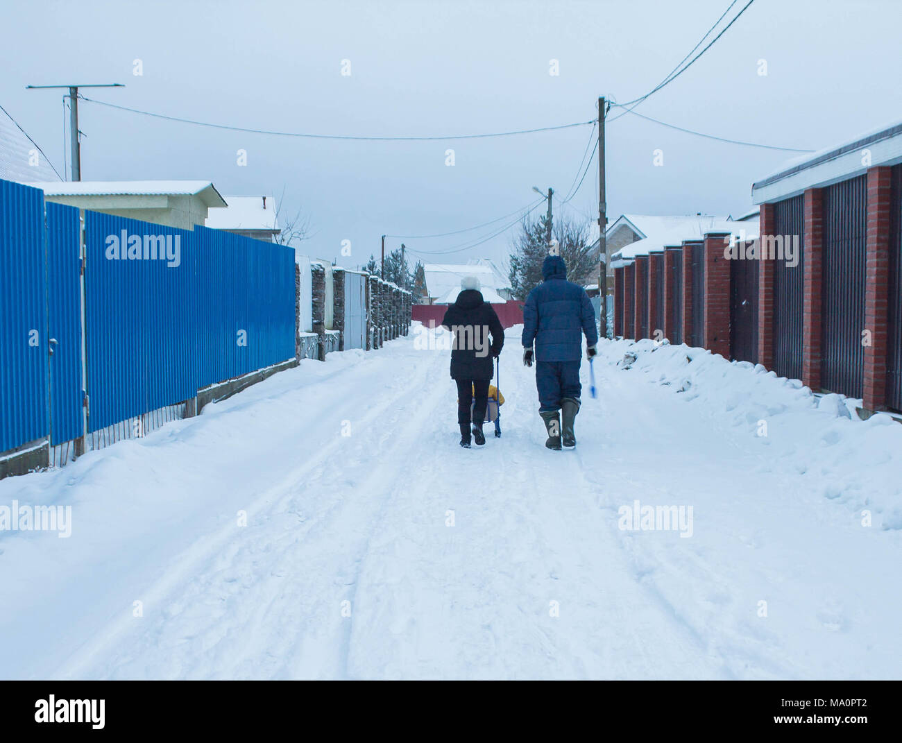 La famiglia è sulla strada del villaggio di inverno Foto Stock