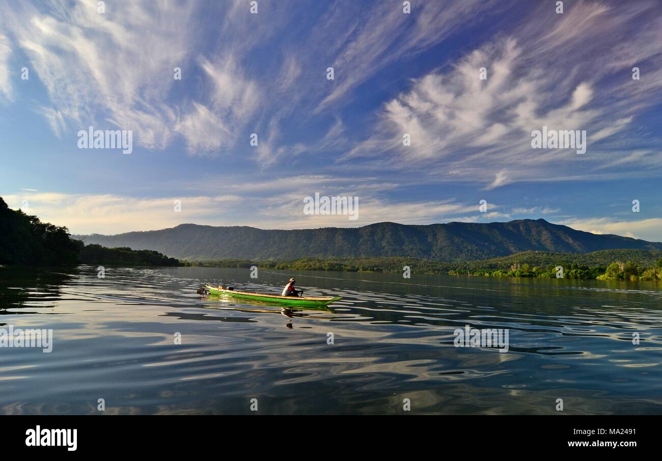 Un pescatore utilizza una canoa attraverso il Riam Kanan lago del Sud Kalimantan, Indonesia. Questo lago pieno di pesci di acqua dolce diventa un magnete per turiste Foto Stock