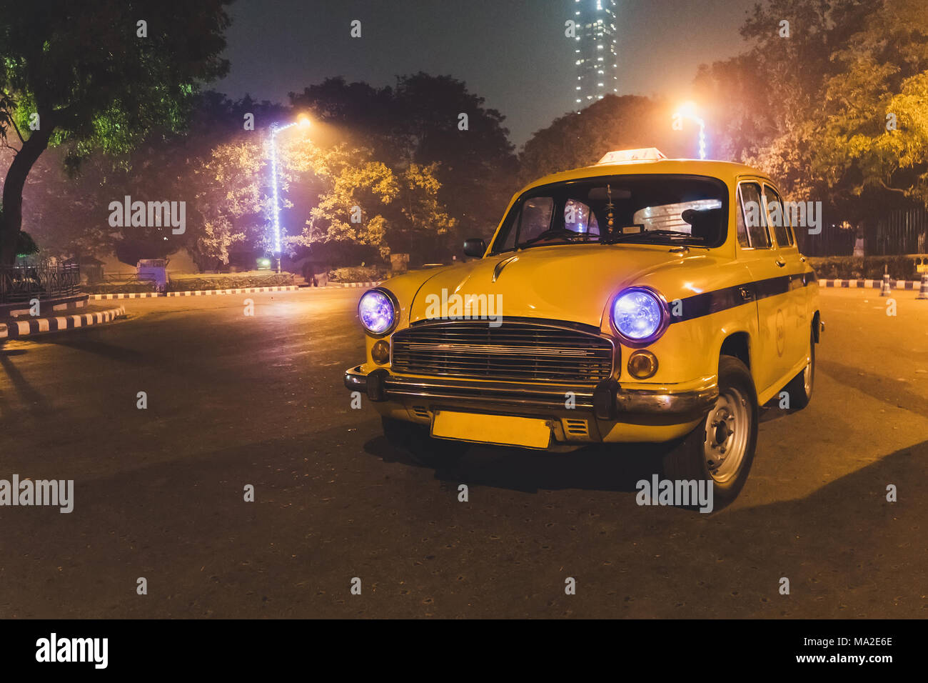 Yellow classic al servizio taxi aeroporto di Kolkata parcheggio a notte. Un taxi modello 50s-60s. Foto Stock
