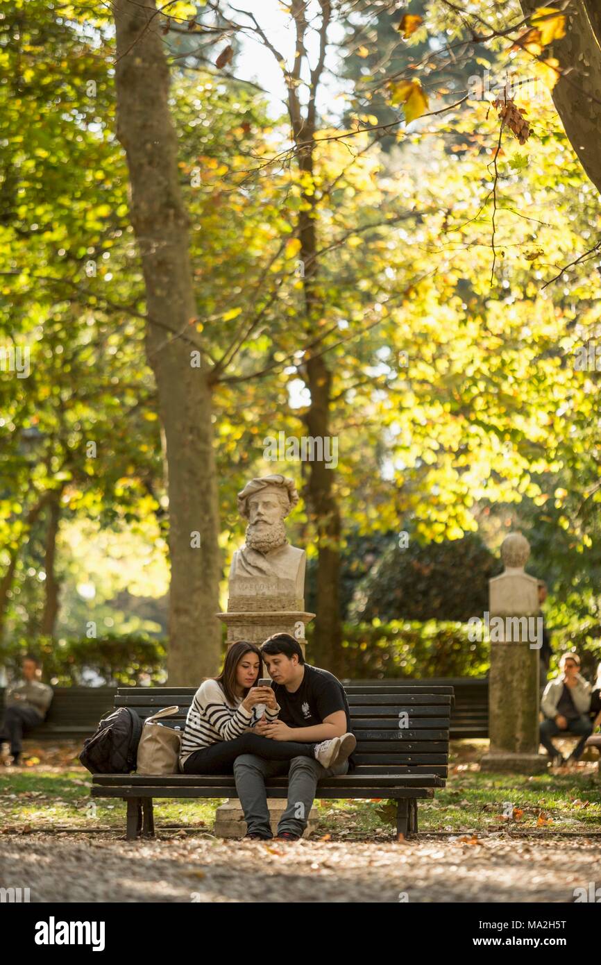 Un giovane su una panchina nel parco di Villa Borghese, Roma Foto Stock