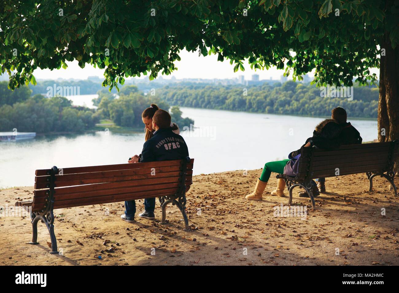 Le coppie seduti sui banchi del parco a Belgrado in Serbia Foto Stock