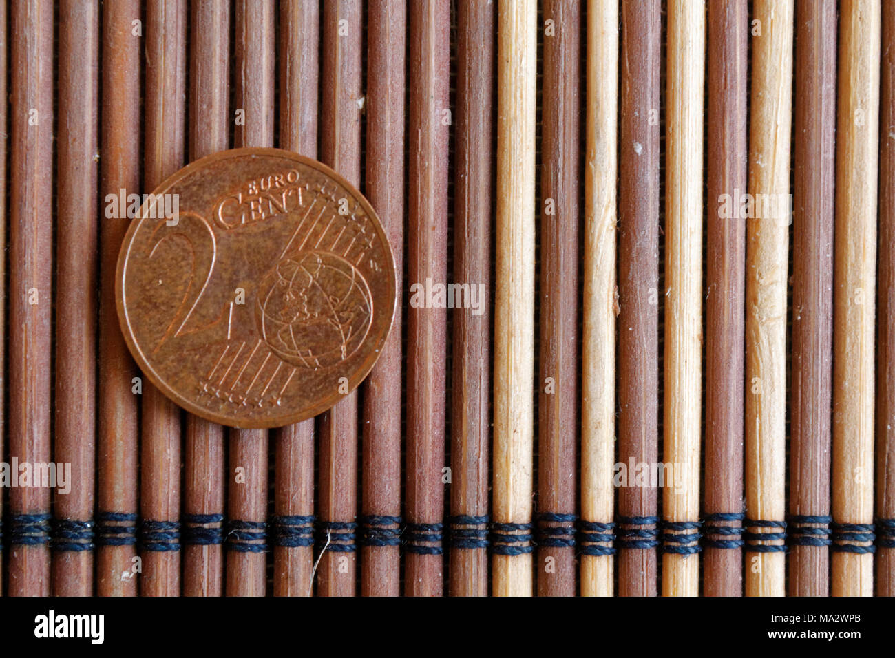 Un euro moneta giacciono su legno tabella di bambù denominazione è di 2 centesimo di euro Foto Stock