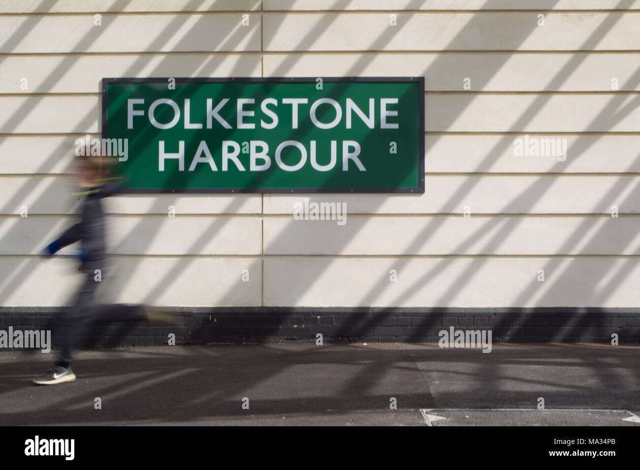 Ragazzo correre per prendere un treno - Folkestone Harbour stazione ferroviaria Foto Stock