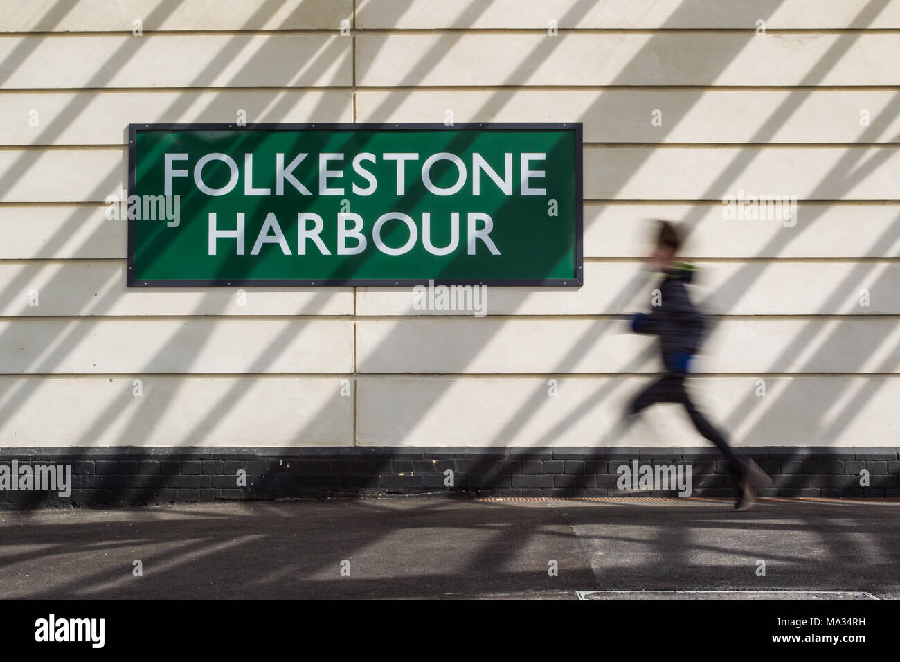 Ragazzo correre per prendere un treno - Folkestone Harbour stazione ferroviaria Foto Stock