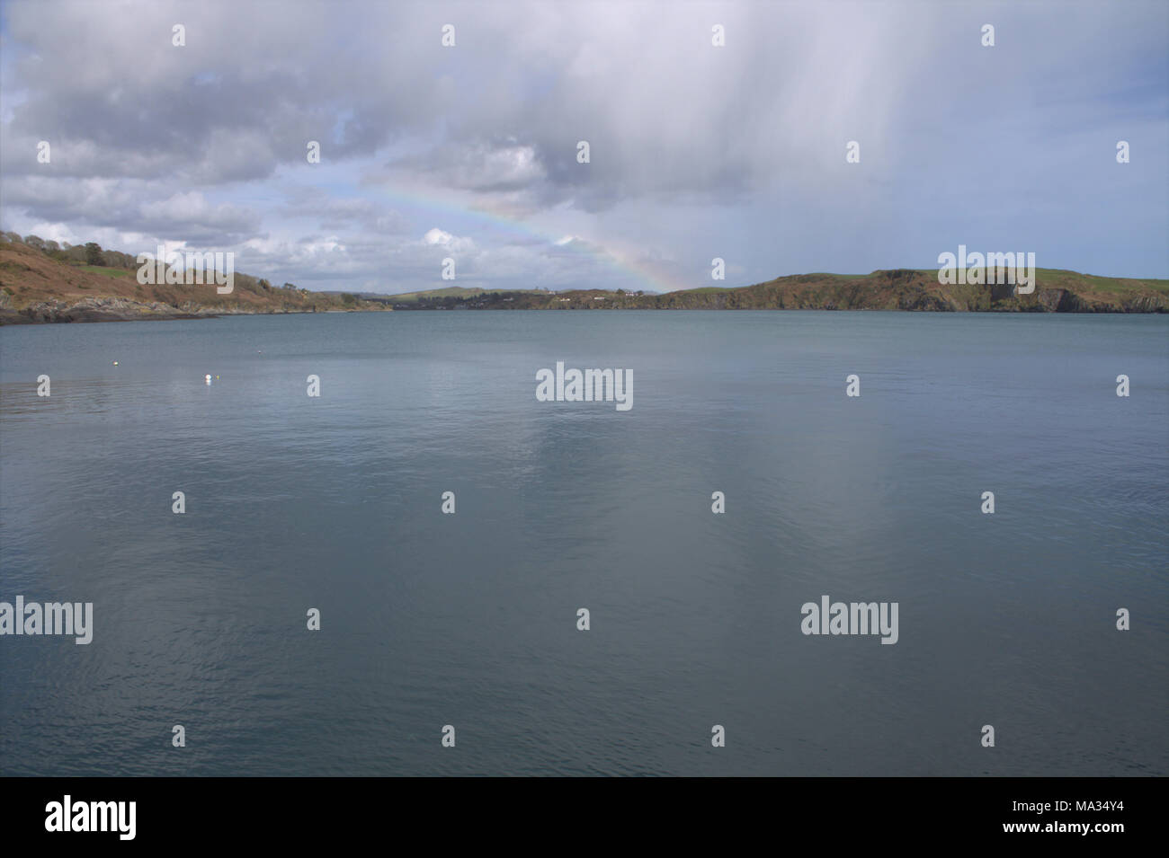 Rainbow formando sul porto ingresso sul litorale irlandese.Irlanda Foto Stock