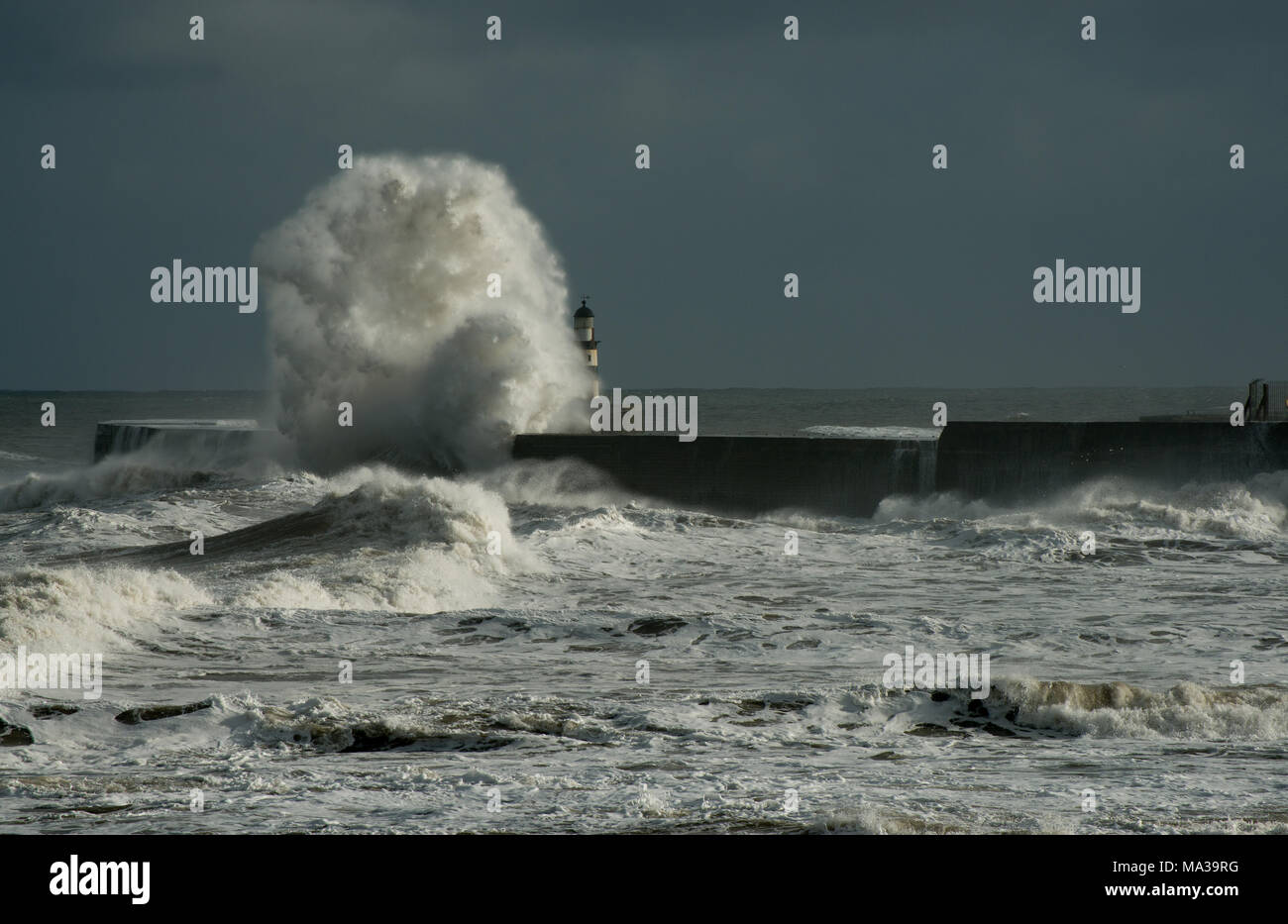 Tempesta onde del Mare del Nord colpito e nano Seaham Harbour faro con uno sfondo cielo scuro Foto Stock