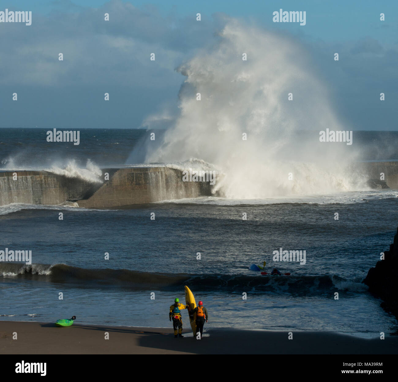 Gli appassionati di kayak al Porto di Seaham si possono ammirare le onde montuose che si infrangono sul molo Foto Stock