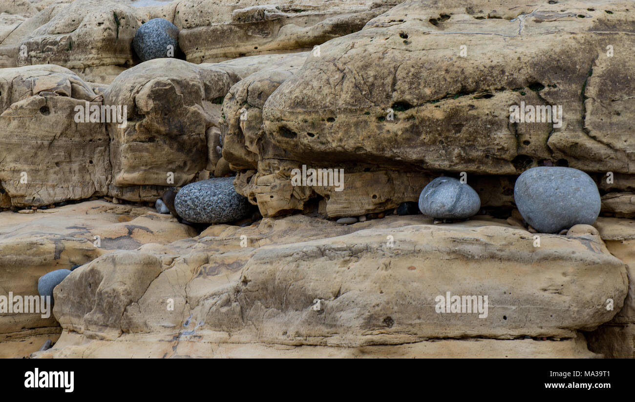 Strati di calcare magnesiano a Seaham nella Contea di Durham con pietre che si infilano negli strati vicino al mare Foto Stock