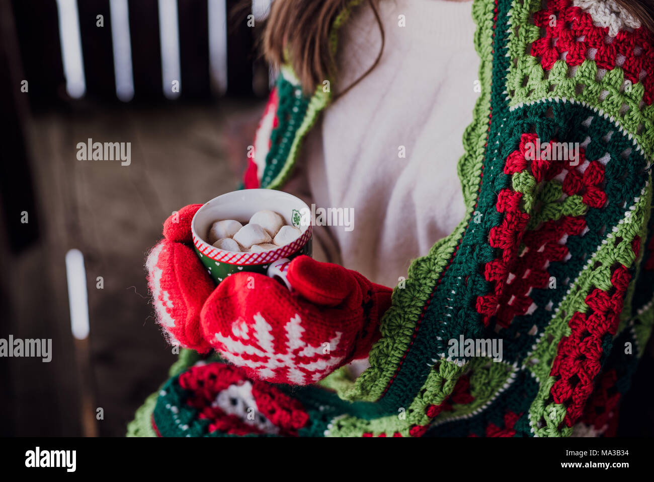 Giovane donna avvolta in una coperta, tenendo in mano un bicchiere,dettaglio, Foto Stock