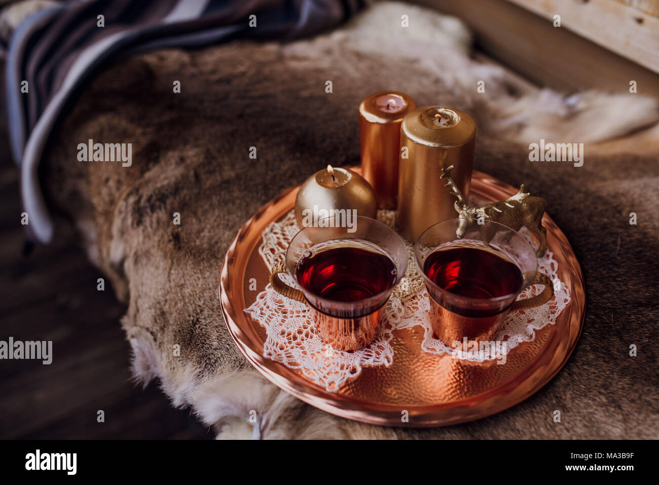 Portico,banco con pelliccia e vassoio con candele e teacups Foto Stock