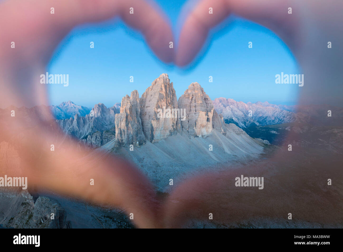 Le mani formando un cuore di incorniciatura dei Tre Cime di Lavaredo, Sesto Dolomiti Alto Adige, Bolzano, Italia Foto Stock