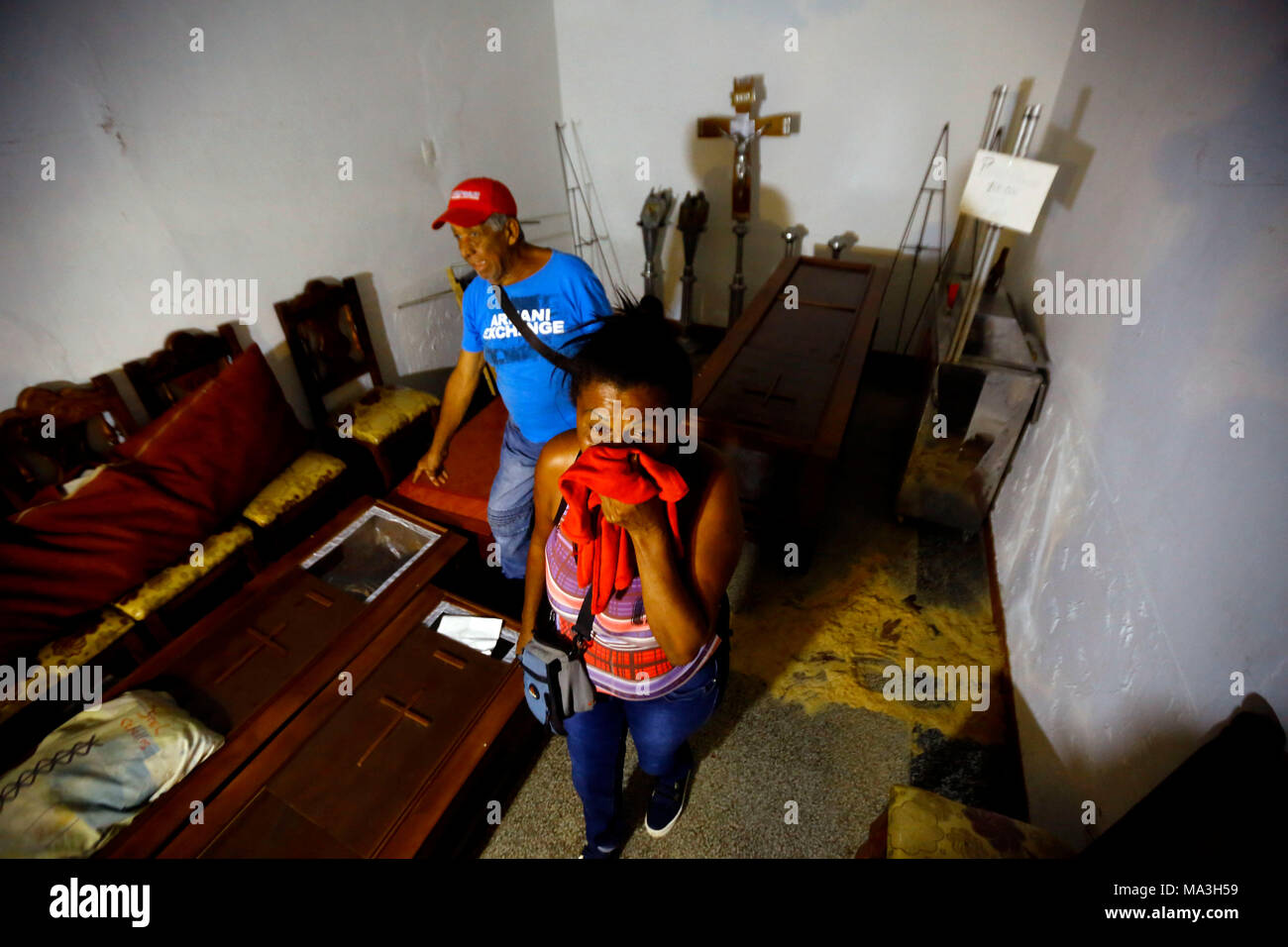 29 marzo 2018, Venezuela, Valencia: Mirian Rosa Oliveros (R) cerca di trovare i suoi parenti tra numerose bare dopo un ammutinamento in una stazione di polizia. Almeno 68 persone sono morte. Secondo fonti locali il mutiny iniziò quando i prigionieri hanno cercato di prendere la loro protezione come un ostaggio. I prigionieri bruciati materassi che ha ottenuto al di fuori del controllo e ha portato a numerosi decessi. Foto: Juan Carlos Hernandez/dpa Foto Stock
