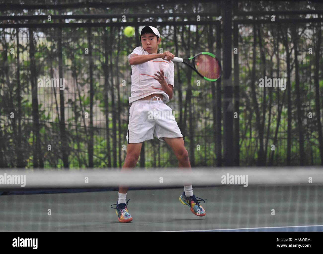 Chengdu, cinese della provincia di Sichuan. 30 Mar, 2018. Dong Chen di Australia restituisce la sfera durante il ragazzo singoli semi-finale contro Ki ng polmone del cinese di Hong Kong alla Cina ITF Junior 6 Grado 3 match di tennis a Chengdu, capitale del sud-ovest della Cina di provincia di Sichuan, 30 marzo 2018. Credito: Liu Kun/Xinhua/Alamy Live News Foto Stock