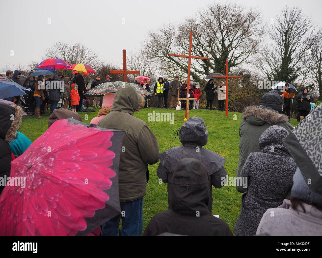 Cattedrale sul mare, Kent, Regno Unito. Il 30 marzo, 2018. Buon Venerdì cerimonia: Chiese insieme in Sheppey (I CTI) annuo Processione del Venerdì Santo di testimonianza. Tre croci di legno sono stati portati da Sheerness, Eastchurch e a metà strada per una cerimonia di premiazione che si terrà sotto la pioggia in cima al Glen in Cattedrale sul mare, uno dei punti più alti del Isle of Sheppey. Il semplice servizio è organizzato per tutte le denominazioni da Chiese insieme in Sheppey (I CTI) ed è stata tenuta sull'isola verde della collina per più di 35 anni. Credito: James Bell/Alamy Live News Foto Stock