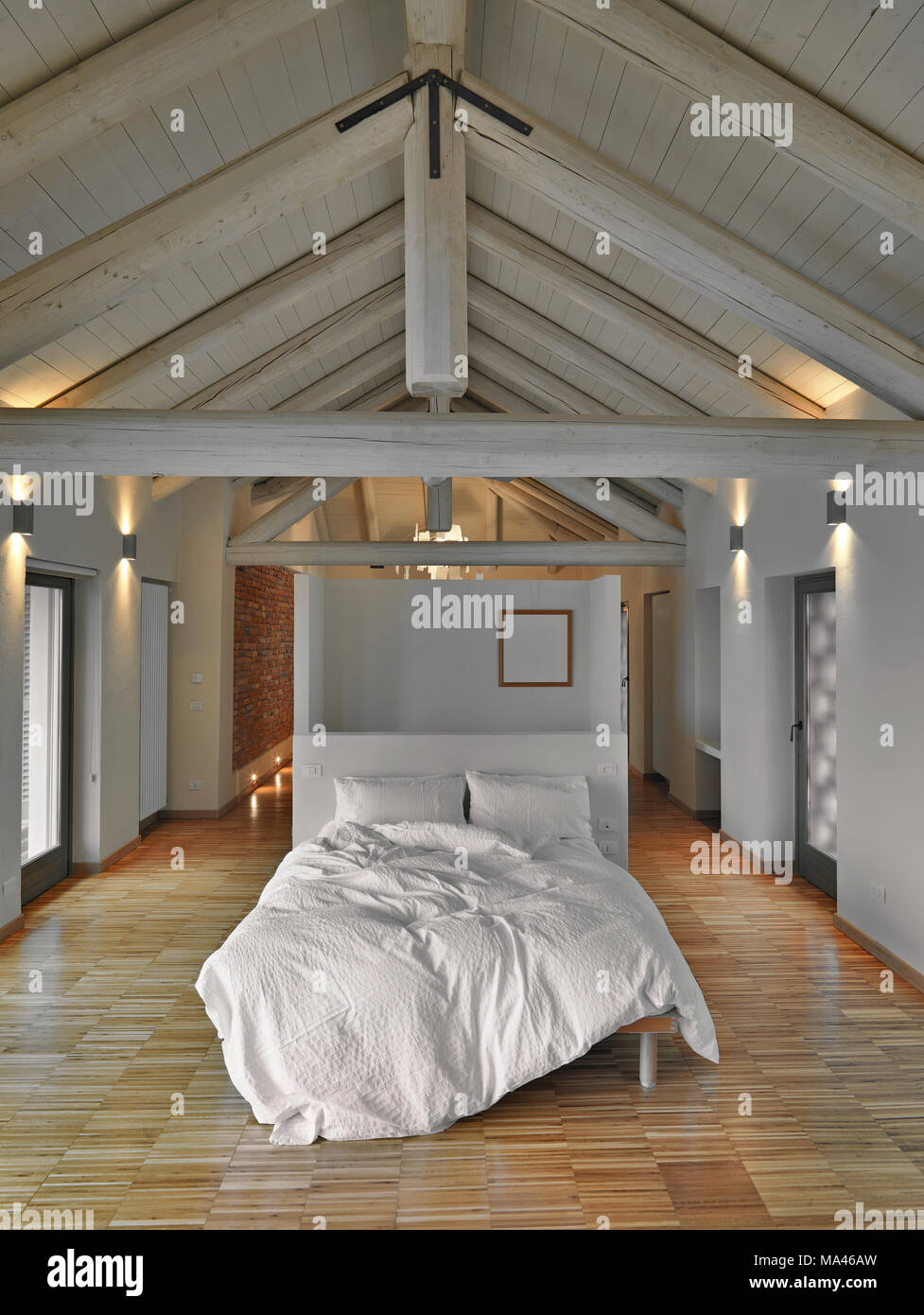 Moderna camera da letto in mansarda camera con soffitto in legno e pavimento in legno Foto Stock