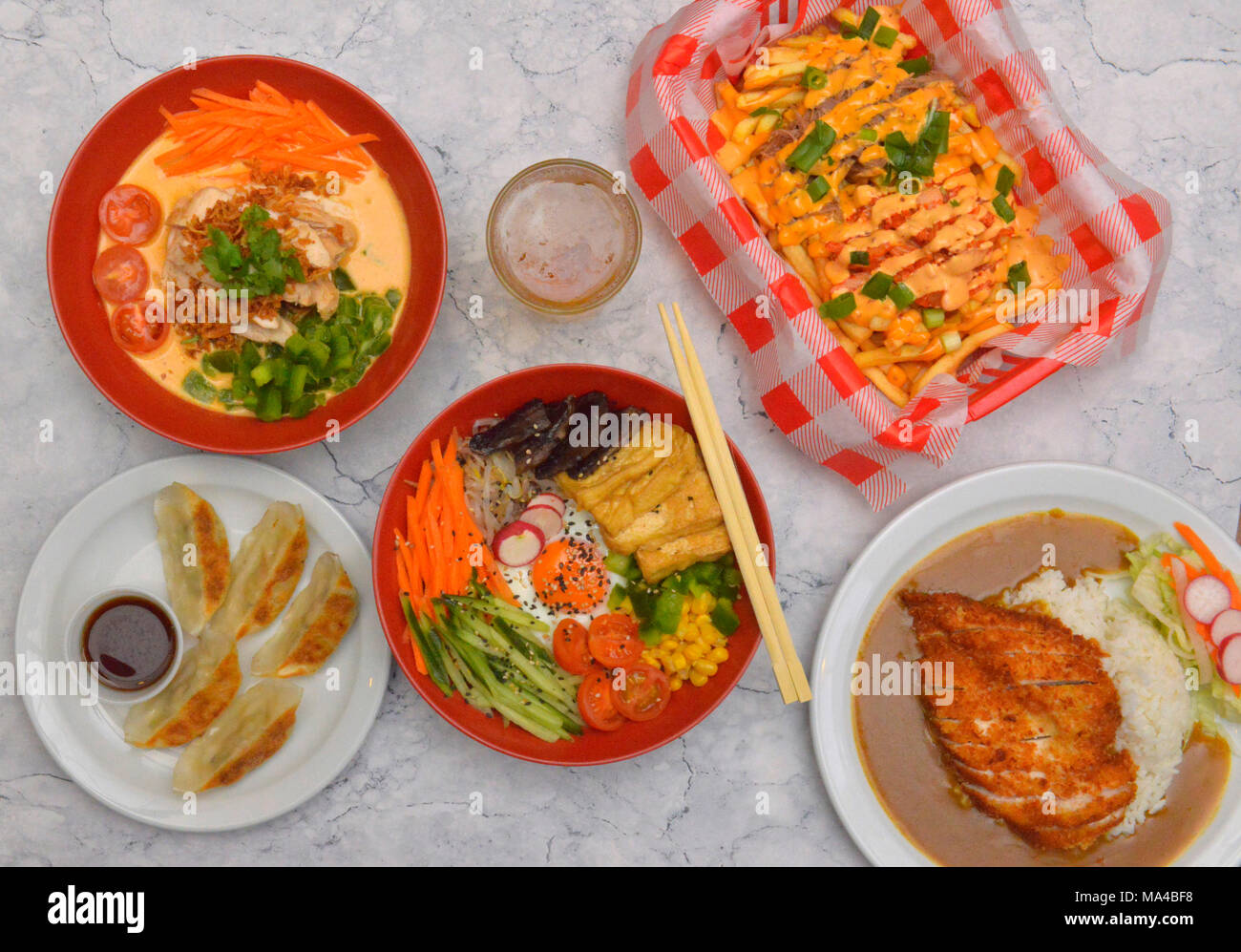 Una selezione di cibo Coreano incluso il tofu & bimbimbap funghi, carni bovine kimchi, pollo al curry rosso, gnocchi di vegetali, Croccante di pollo panko katsu curry. Foto Stock