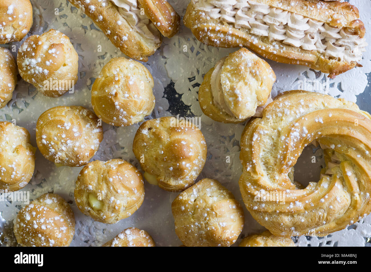 Un regime di dolci cremosi su una tovaglia bianca. Foto Stock