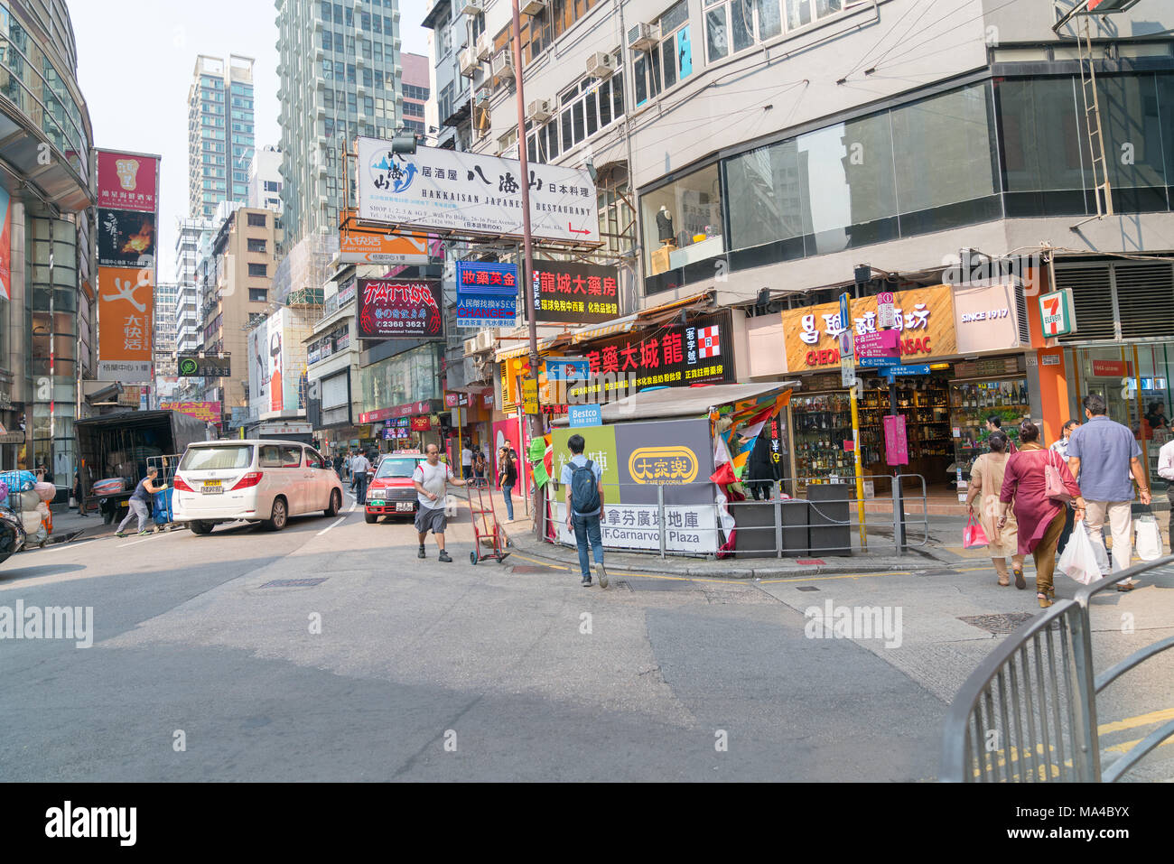 KOWLOON, HONG KONG - 18 settembre 2017; tipicamente città asiatiche scena di strada nella zona di intersezione con il traffico, le persone che attraversano, man mano con carrello shop fro Foto Stock