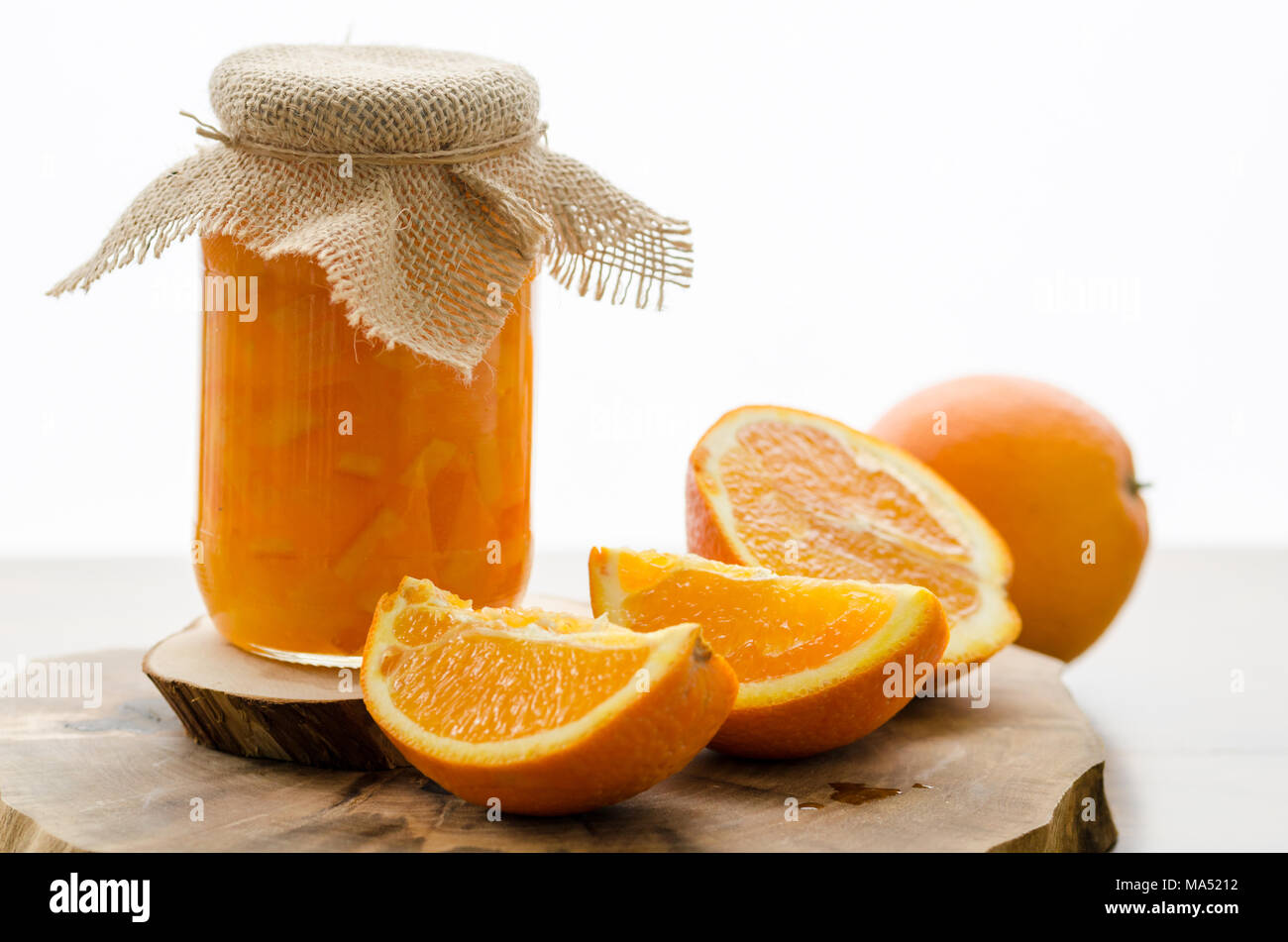 Orange marmellata fatta in casa e fette di arance sul tavolo di legno Foto Stock