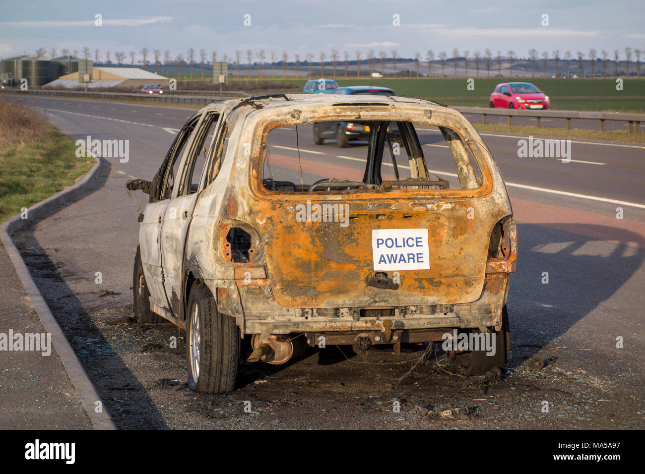Danneggiato abbandonato bruciato auto rimane a lato della strada, REGNO UNITO Foto Stock
