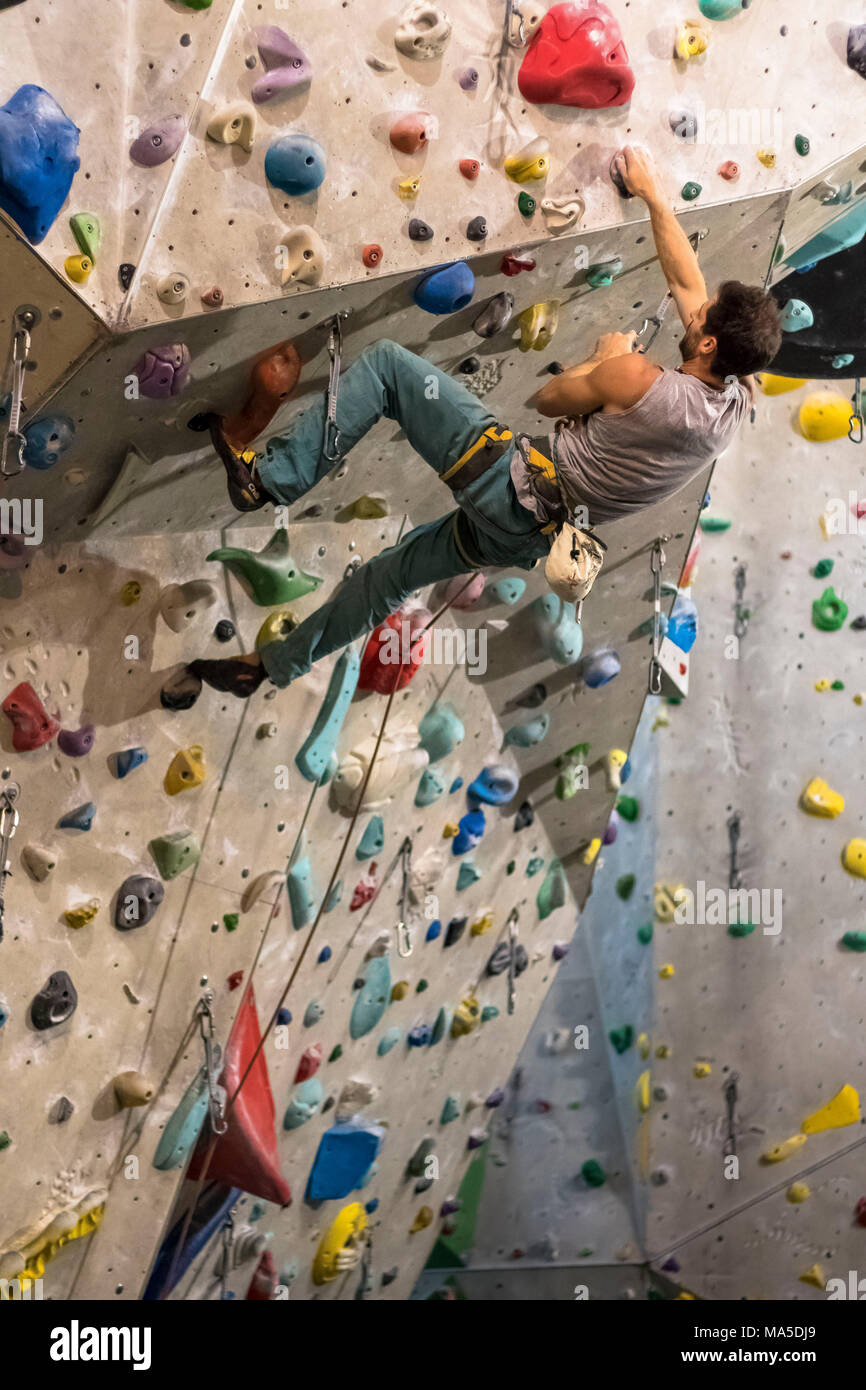 Germania, Baden-Württemberg, Stoccarda, palestra di arrampicata, femmina scalatore in una sporgenza sulla parete di arrampicata Foto Stock