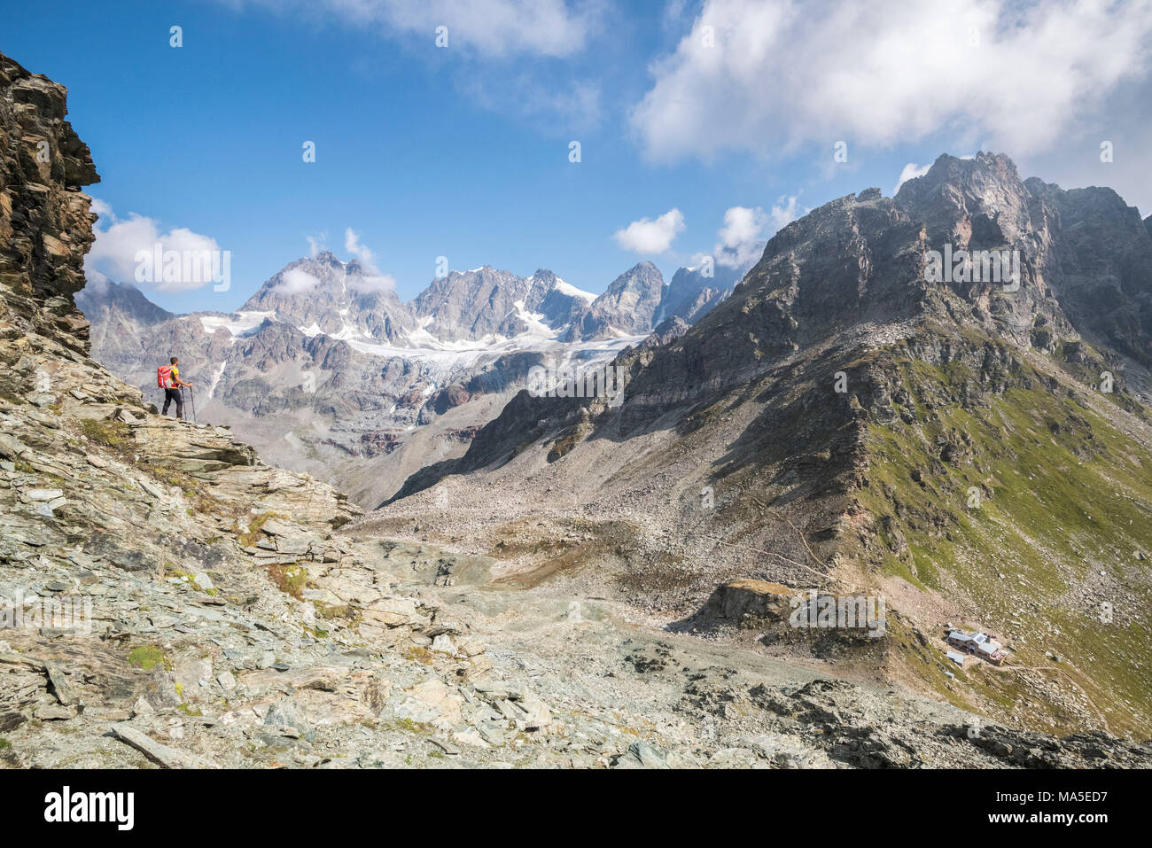 Escursionista guardando il ghiacciaio e le cime del gruppo del Bernina sopra il Rifugio Carate Brianza, Valmalenco, provincia di Sondrio e della Valtellina, Lombardia, Italia Europa Foto Stock