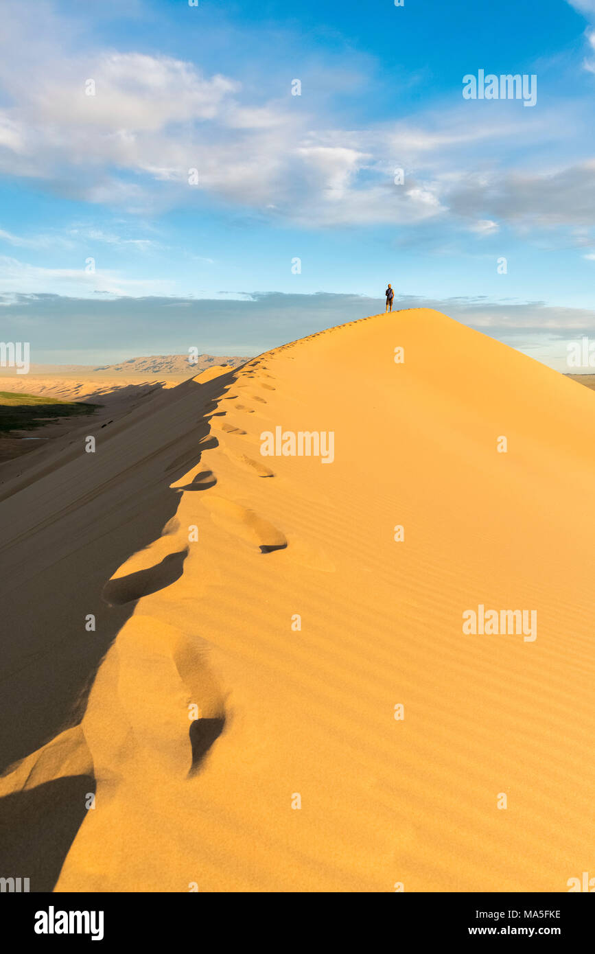 Uomo che cammina su Khongor dune di sabbia in Gobi Gurvan Saikhan Parco Nazionale. Sevrei distretto, a sud della provincia di Gobi, Mongolia. Foto Stock