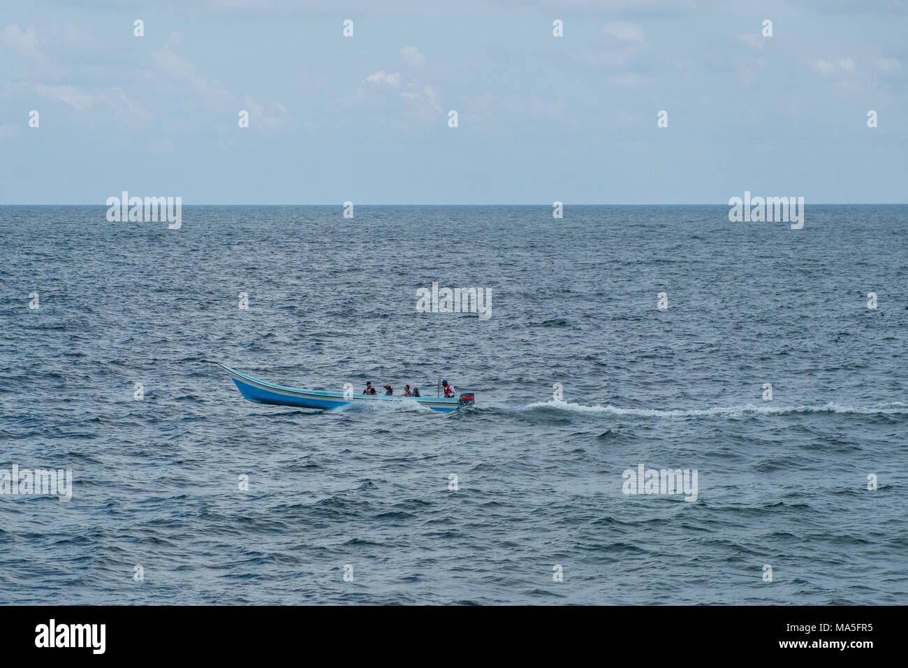 Piccolo motoscafo in legno su ocean - persone in barca Foto Stock