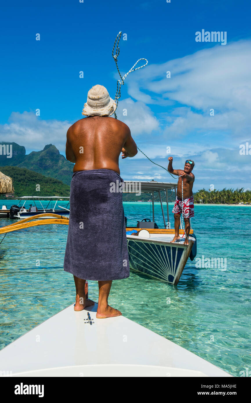 Gli uomini locali ancoraggio su un piccolo Motu, Bora Bora, Polinesia Francese Foto Stock