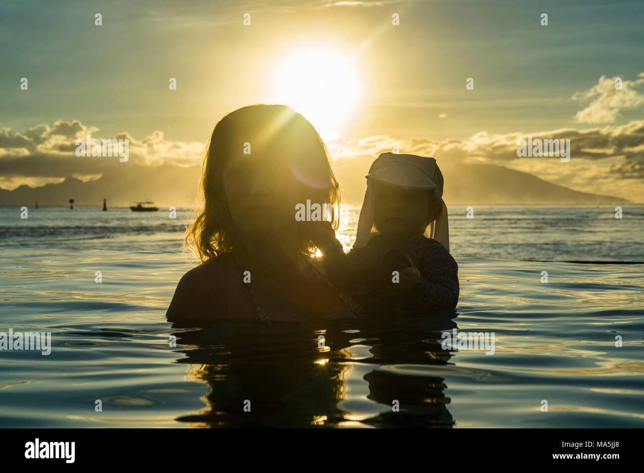 Donna che gioca con il suo bambino al tramonto, Papeete, Tahiti, Polinesia Francese Foto Stock